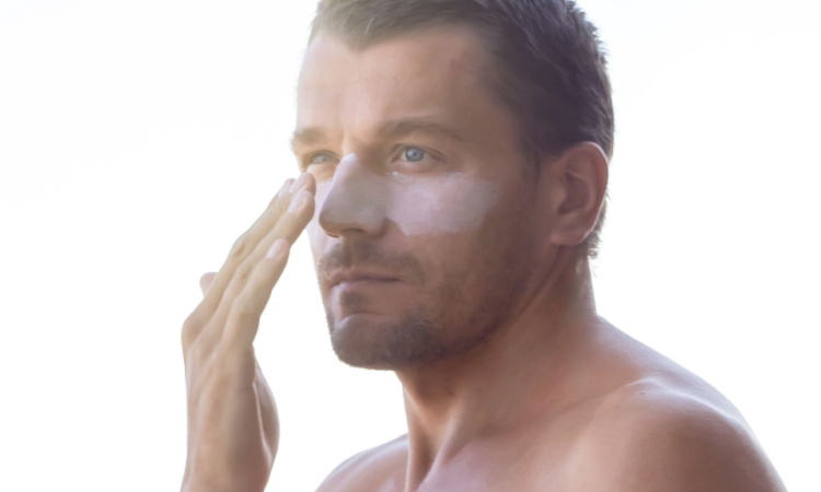 Man applying sunscreen to his face